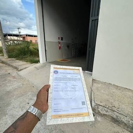 Documento do certificado em mãos na entrada do imóvel atendido