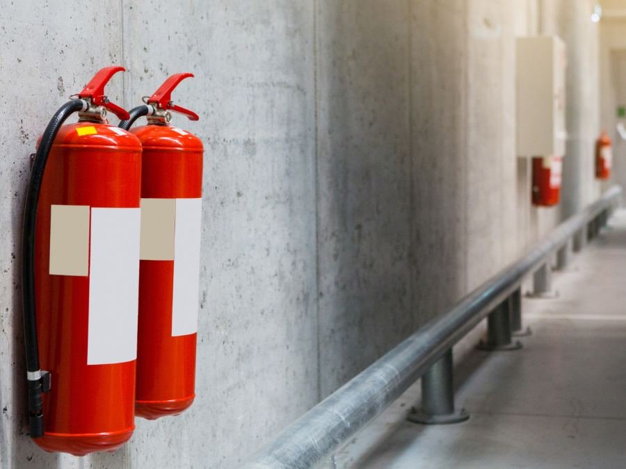 Extintores instalados na parede de um corredor de garagem
